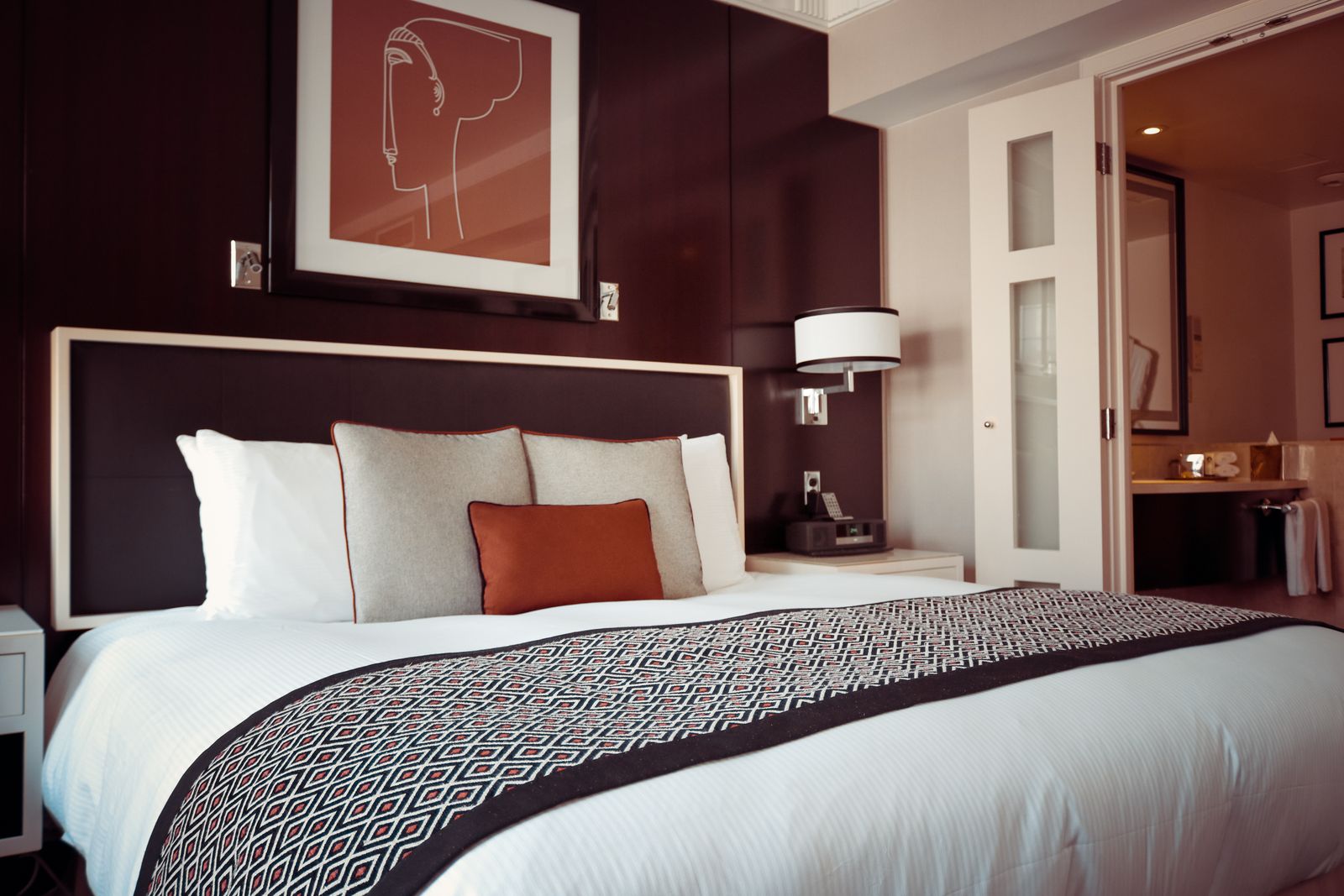 Bedroom with an upholstered bed, wood nightstand, and linen bedding